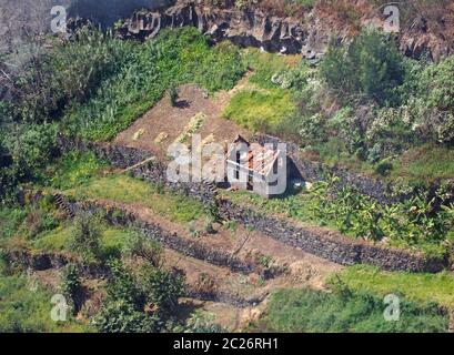 vue aérienne d'une ferme abandonnée en ruines entourée de champs en terrasses fortifiés typiques d'une petite agriculture à l'ancienne Banque D'Images