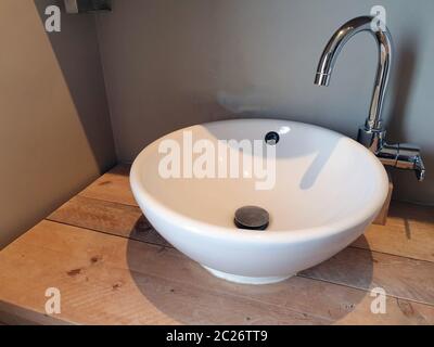 Blanc élégant lavabo, évier en porcelaine blanche de luxe sur table en bois moderne salle de bains Banque D'Images