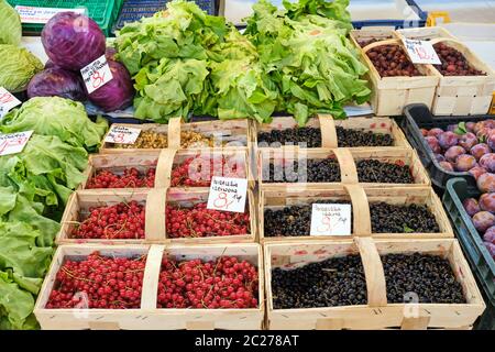 Les baies de cassis dans de petits paniers et de la laitue à la vente à un marché Banque D'Images