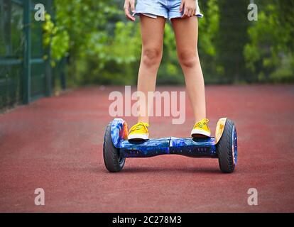 Pieds de la petite fille qui monte sur un segway Banque D'Images