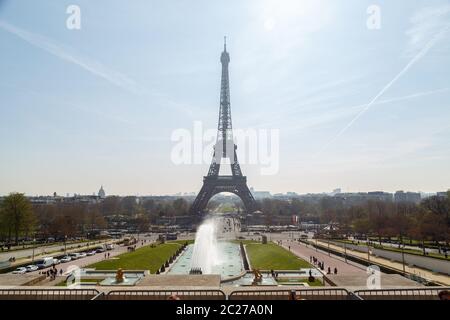 La tour Eiffel dans un ciel bleu clair avec un peu de nuage. Parc champ de Mars et les gens en premier plan Banque D'Images