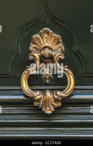 Détail d'un knocker en métal bronze sur une porte de maison en bois Banque D'Images