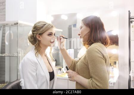 Un maquilleur professionnel fait du maquillage dans un salon de beauté Banque D'Images
