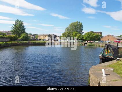 une vue sur l'entrée de l'écluse du bassin de la brightouse avec des bateaux amarrés sur le calder et le canal de navigation de galets dans le calderson we Banque D'Images