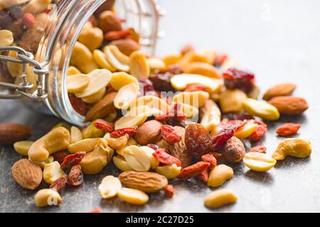 Mélange de diverses noix et raisins dans le bocal sur la vieille table de cuisine. Banque D'Images