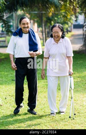 Portrait couple senior marchant dans le parc Banque D'Images