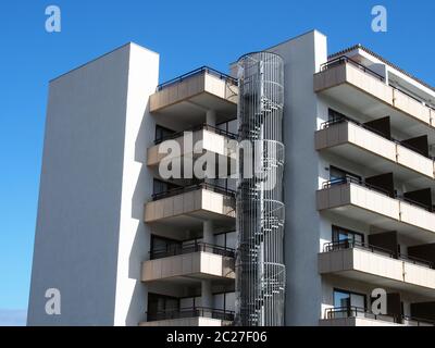 immeuble moderne avec cheminée circulaire en métal avec escalier en colimaçon et balcons élégants et angulaires Banque D'Images