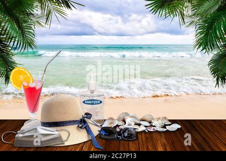 Vacances dans la nouvelle normalité après la pandémie du coronavirus COVID-19. Concept de tourisme montrant la plage avec désinfectant pour les mains, masque médical au visage parmi la plage ha Banque D'Images