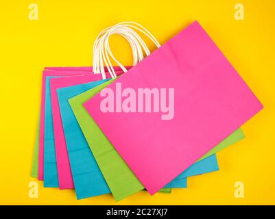 Multi-couleur rectangulaire des sacs en papier avec poignées blanc sur fond jaune, télévision lay Banque D'Images