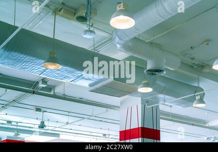 Conduit d'air, de l'air système de ventilation dans shopping mall. Tuyau de climatisation et plomberie . Lampe de plafond avec lumière a ouvert la lumière. En construction Banque D'Images