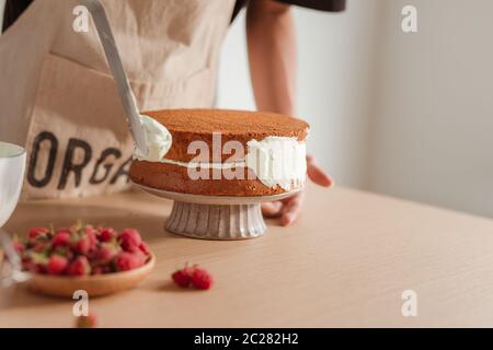 Chef pâtissier met la crème sur les gâteaux. Gâteau de cuisson du processus. Banque D'Images