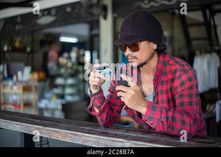 Les hommes hipster asiatiques tiennent des cartes de crédit et utilisent des téléphones mobiles pour faire des achats en ligne. Banque D'Images