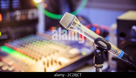 Microphone dans le studio d'enregistrement, équipement dans l'arrière-plan flou Banque D'Images