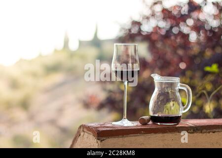 Verre de vin rouge en Toscane. Vignobles en arrière-plan. Banque D'Images