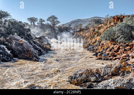 Belle Epupa Falls sur la rivière Kunene au nord de la Namibie et du sud de l'Angola frontière. Lever du soleil la lumière du soleil dans l'eau de la brume. C'est l'Afrique. Magnifique la Banque D'Images