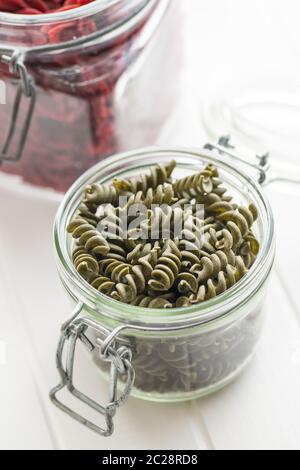 Pâtes colorées non cuites avec saveur épinards en pot. Banque D'Images