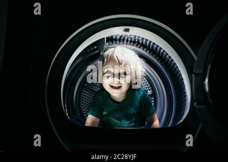 Enfant heureux, assis dans un sèche-cheveux à pied, souriant avec joie Banque D'Images