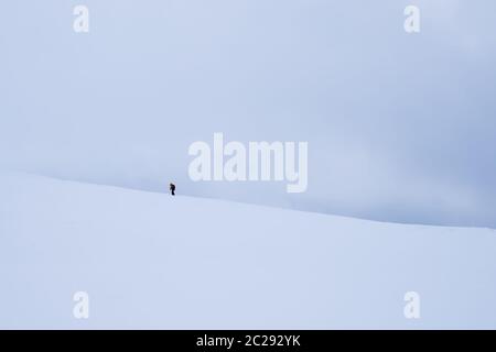 Personne non identifiable à marcher vers le sommet de montagne Storsteinen et le pic dans la neige parmi les merveilleux paysages d'hiver, la Norvège Banque D'Images