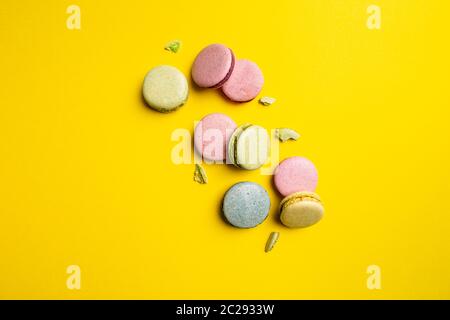 Gâteaux de macaron colorés sur fond jaune, espace pour votre texte Banque D'Images