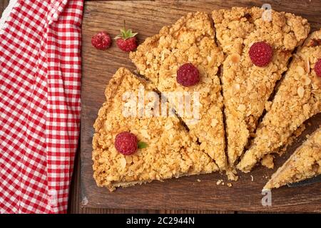 Fabricants de pièces triangulaires de tarte crumble aux pommes sur une planche de bois brun, vue du dessus Banque D'Images