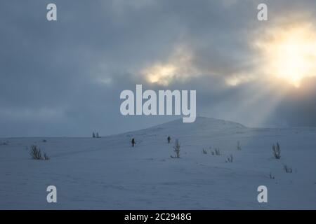 Les personnes non identifiables à marcher vers le sommet de montagne Storsteinen et le pic dans la neige parmi les merveilleux paysages d'hiver, la Norvège Banque D'Images