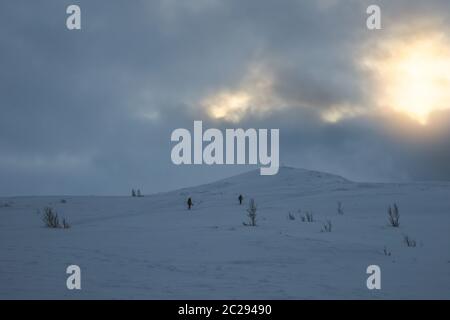 Les personnes non identifiables à marcher vers le sommet de montagne Storsteinen et le pic dans la neige parmi les merveilleux paysages d'hiver, la Norvège Banque D'Images