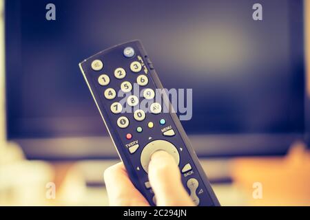 Main mâle tenant la télécommande du téléviseur, Smart TV. Banque D'Images