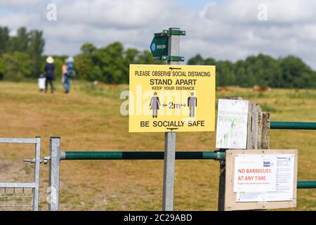 Un panneau indiquant aux randonneurs et aux gens de garder 2 m à l'écart tout en se relaxant et en marchant dans les parcs publics du Royaume-Uni Banque D'Images