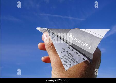 AFFAIRES, main avec avion papier Banque D'Images