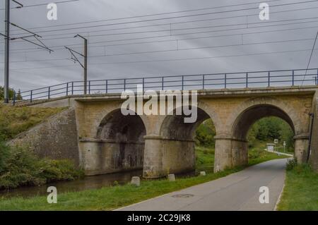 Pont de chemin de fer à trois arcades, deux pour la rivière de la tonalité et une pour l'tarmaker Road dans la ville de Virton dans la province de Luxembourg en B Banque D'Images