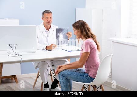 Vue latérale du genou montrant médecin radiographie pour Female Patient In Clinic Banque D'Images