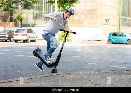 Homme qui tombe d'accident sur l'E-Scooter Street Banque D'Images