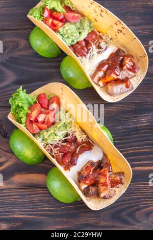 Les tacos avec des remplissages sur la table en bois Banque D'Images