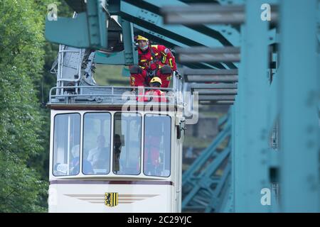 Dresde, Allemagne. 17 juin 2020. Les participants à un exercice de rappel de la brigade des pompiers de Dresde grimpent sur le toit dans une voiture de la suspension historique du chemin de fer à une hauteur de dix mètres à mi-chemin entre la vallée et les stations de montagne. Une fois par an, les pompiers, en collaboration avec l'autorité de transport de Dresde (DVB), s'assessent des passagers en détresse à la suite d'un transport du chemin de fer suspendu construit en 1901. Credit: Sebastian Kahnert/dpa-Zentralbild/ZB/dpa/Alay Live News Banque D'Images