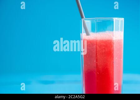 Des smoothies, des jus de pastèque jus dans un verre transparent sur un fond de bois bleu Banque D'Images