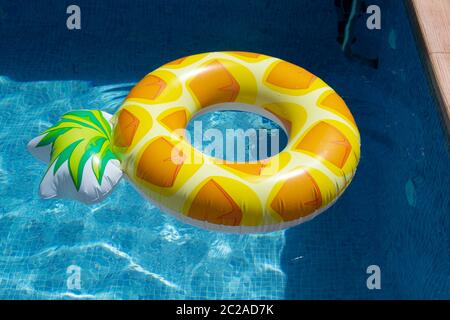 Ananas gonflable ring floating in swimming pool Banque D'Images