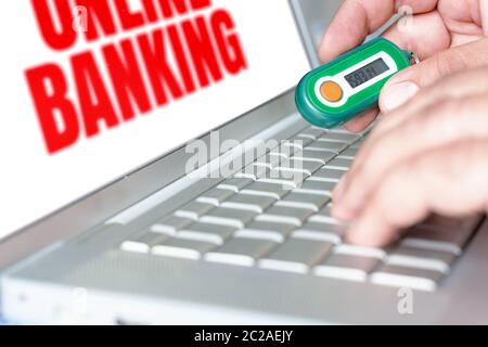 homme utilisant un générateur de mot de passe pour effectuer des opérations bancaires en ligne Banque D'Images