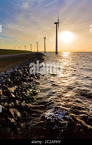 Magnifique vue sur le lac Markermeer avec de multiples éoliennes modernes pour une énergie verte durable aux pays-Bas au coucher du soleil Banque D'Images