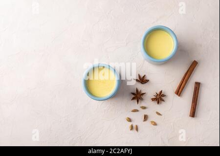 Deux tasses bleues avec thé traditionnel indien masala chai avec épices sur fond clair. Vue de dessus avec espace de copie Banque D'Images