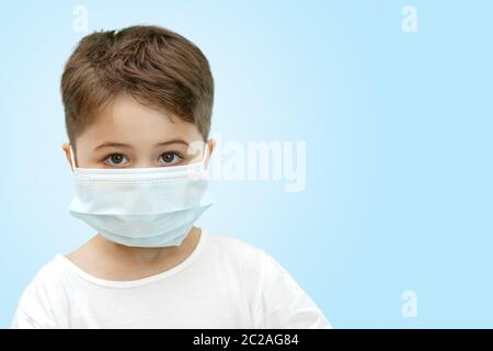 Peu Caucasian boy in medical masque sur fond isolé Banque D'Images