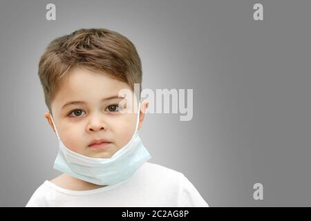 Peu Caucasian boy in medical masque sur fond isolé Banque D'Images