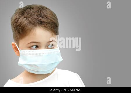 Peu Caucasian boy in medical masque sur fond isolé Banque D'Images