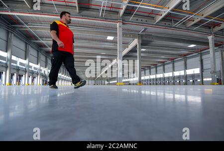 Ludwigsfelde, Allemagne. 17 juin 2020. Un livleur passe à travers la coquille vide d'un centre de colis Deutsche Post. Le même jour, la première phase de construction a été achevée avec l'achèvement de la coquille du nouveau centre de colis. À l'avenir, jusqu'à 50,000 colis par heure seront triés dans le centre de colis. Selon la société, le troisième « centre de colis DHL » en Allemagne et l'un des plus modernes d'Europe est construit sur environ 165,000 mètres carrés. Plus de 600 nouveaux emplois seront créés dans la région. Credit: Patrick Pleul/dpa-Zentralbild/dpa/Alay Live News Banque D'Images