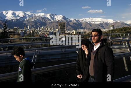 Le peuple iranien traverse le pont piétonnier moderne de Tabiat, jusqu'au parc Taleghani, avec les montagnes enneigées d'Alborz en arrière-plan, à Téhéran. Banque D'Images