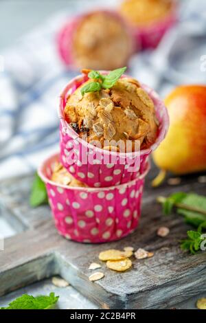 Muffins fraîchement cuits avec poire sous forme de papier. Banque D'Images