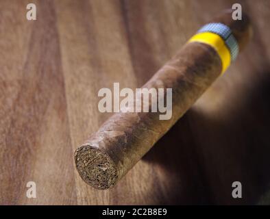 Cigare roulé d'une feuille de tabac sur fond en bois, petite profondeur de netteté Banque D'Images