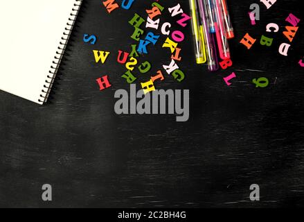 Les petites lettres en bois multicolores de l'alphabet anglais sur un tableau noir, l'espace de copie, le retour à l'école Banque D'Images