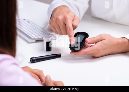 Doctor Showing The Lancet et diabete numérique stylo pour femme pour contrôler le niveau de sucre dans le sang Banque D'Images