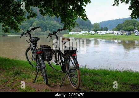 Bad Karlshafen, Allemagne. 17 juin 2020. Les bicyclettes se trouvent sous les arbres sur les rives du Weser, au bord du sentier de randonnée. De l'autre côté le camping du village. Credit: Uwe Zucchi/dpa/Alay Live News Banque D'Images
