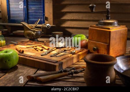 Encore plus de vie avec des plats anciens et des pommes vertes. Moulin à café nostalgique sur une table ancienne et un fond en bois texturé. Un éclairage cinématographique fixe Banque D'Images